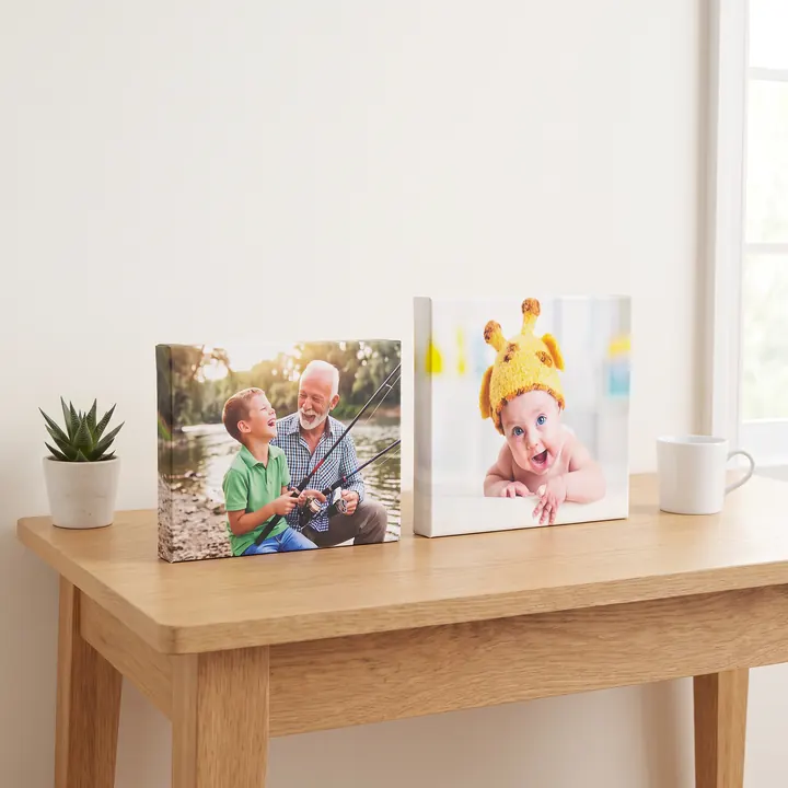 Two small desktop canvases on an oak desk, one landscape and one square