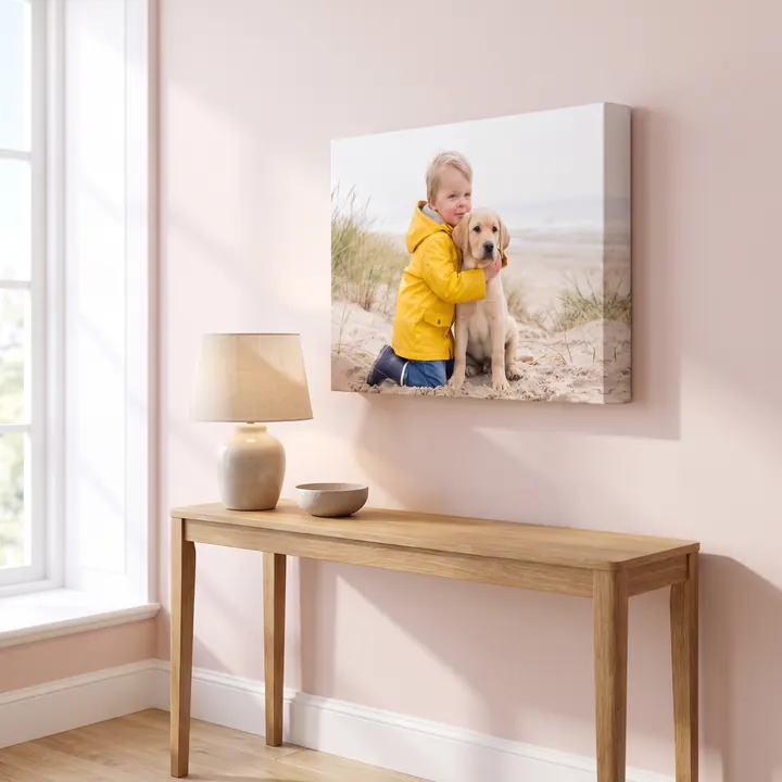 A large pro canvas of a boy hugging a labrador above an oak console table in a hallway