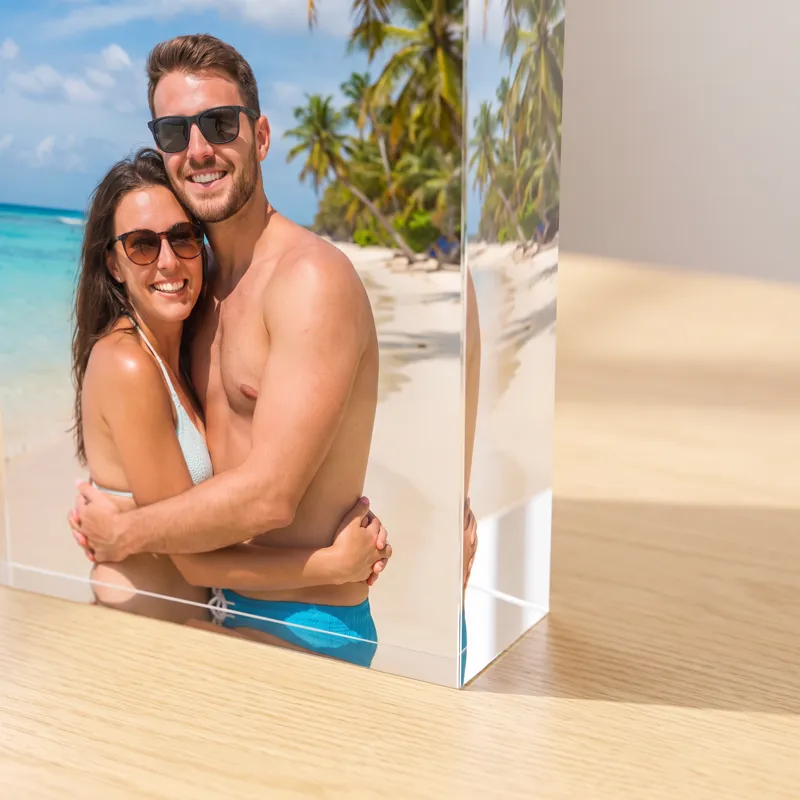 The corner of an acrylic photo block: a beach photo printed edge to edge on the back, seen through 20mm of clear polished acrylic