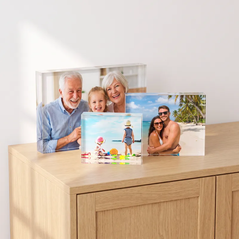 Three acrylic photo blocks in different sizes on a pale oak sideboard