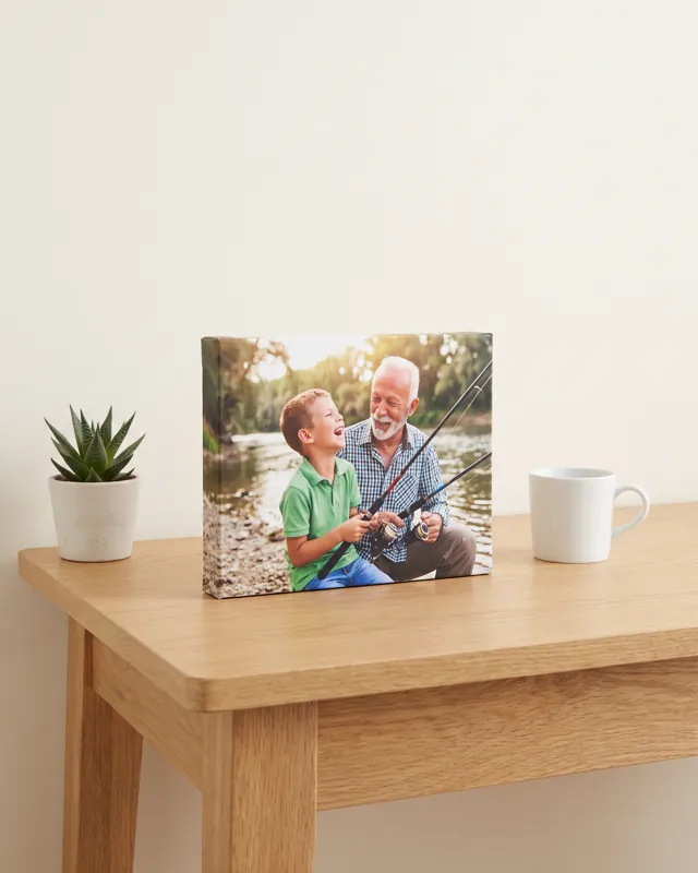 A desktop canvas of a grandad and grandson fishing, standing on an oak desk