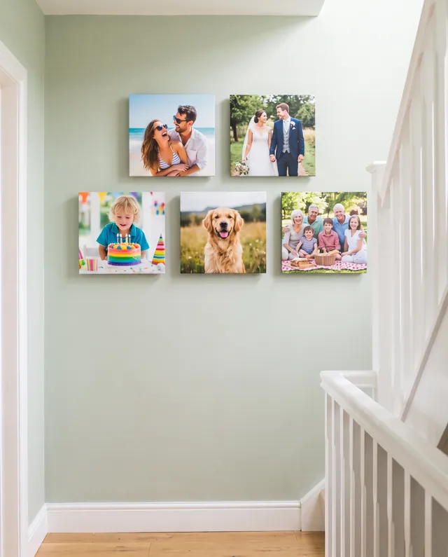 A set of five Floto photo tiles of family moments on a hallway wall by the stairs