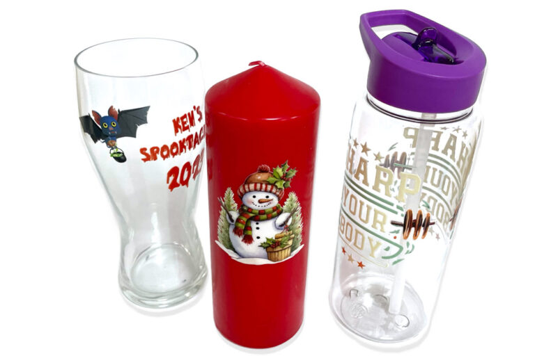 Gloss UV DTF transfers on a pint glass, a candle and a water bottle